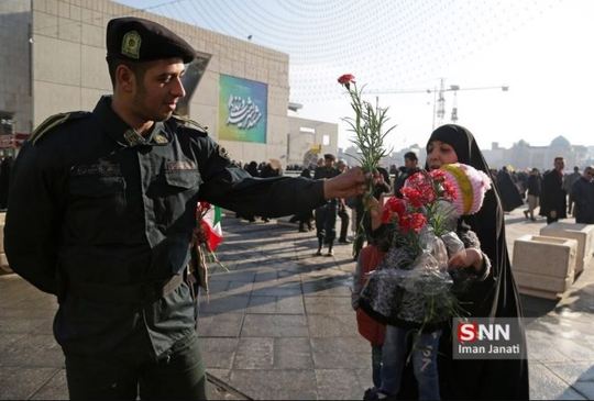  اهدای گل به حافظان امنیت در راهپیمایی مشهد