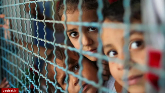 نگاه معصومانه کودکان آواره فلسطینی از پشت حصار پنجره مدرسه ای که به آن پناهنده شده اند