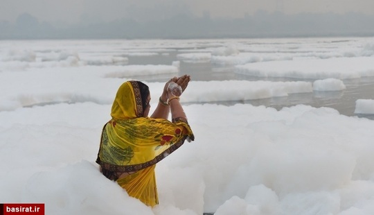 در حالی که کف سمی روی سطح رودخانه آلوده یامونا در دهلی نو شناور است، یک هندو در حال برگزاری مراسم سنتی خود است