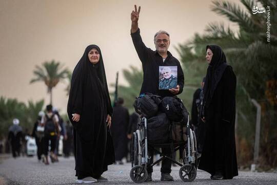 زائران اربعین حسینی در مسیر پیاده روی نجف تا کربلا با تصویر شهید حاج قاسم سلیمانی عکس یادگاری گرفتند.